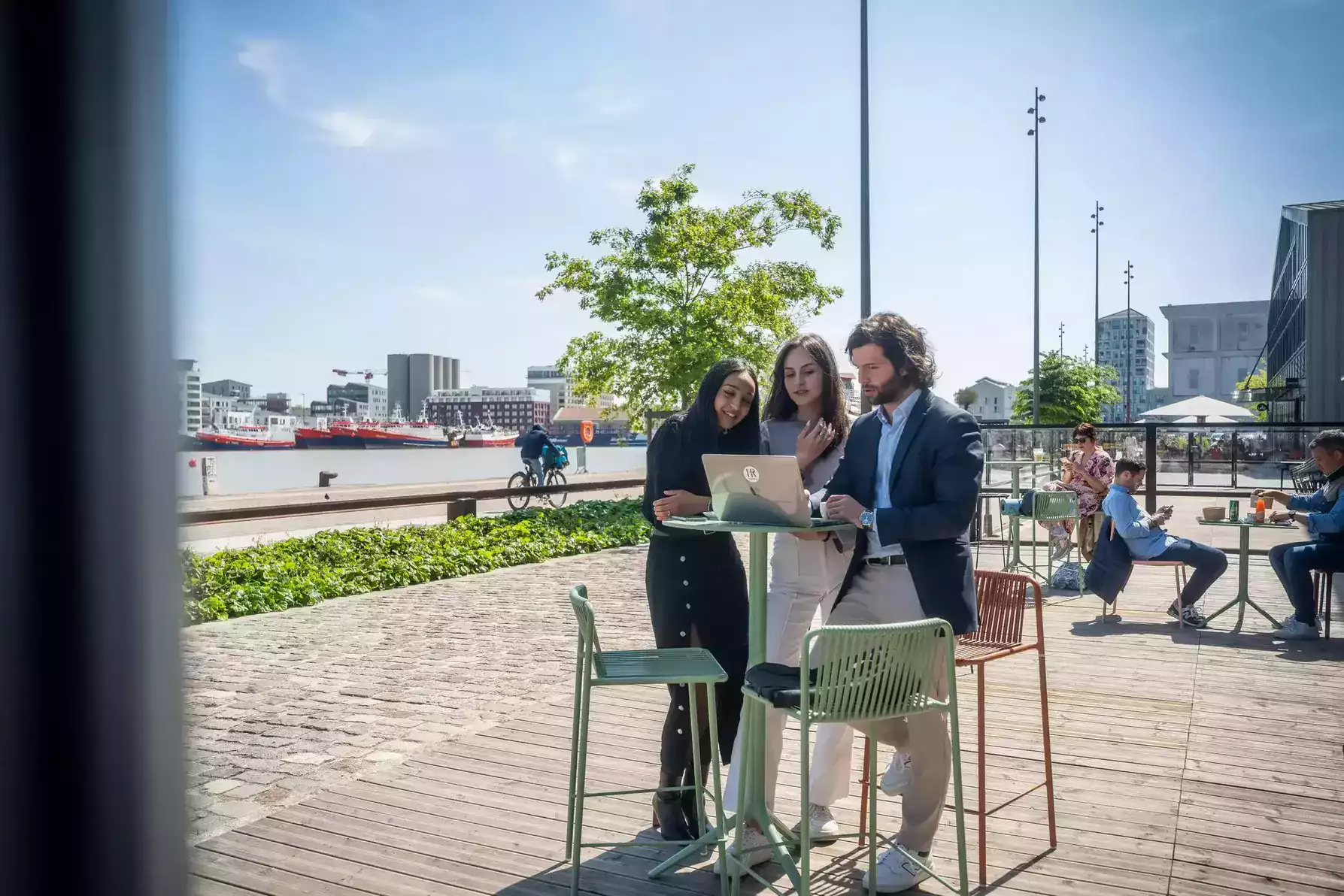 Equipe debout à une table du coworking en train de travailler sur l'ordinateur